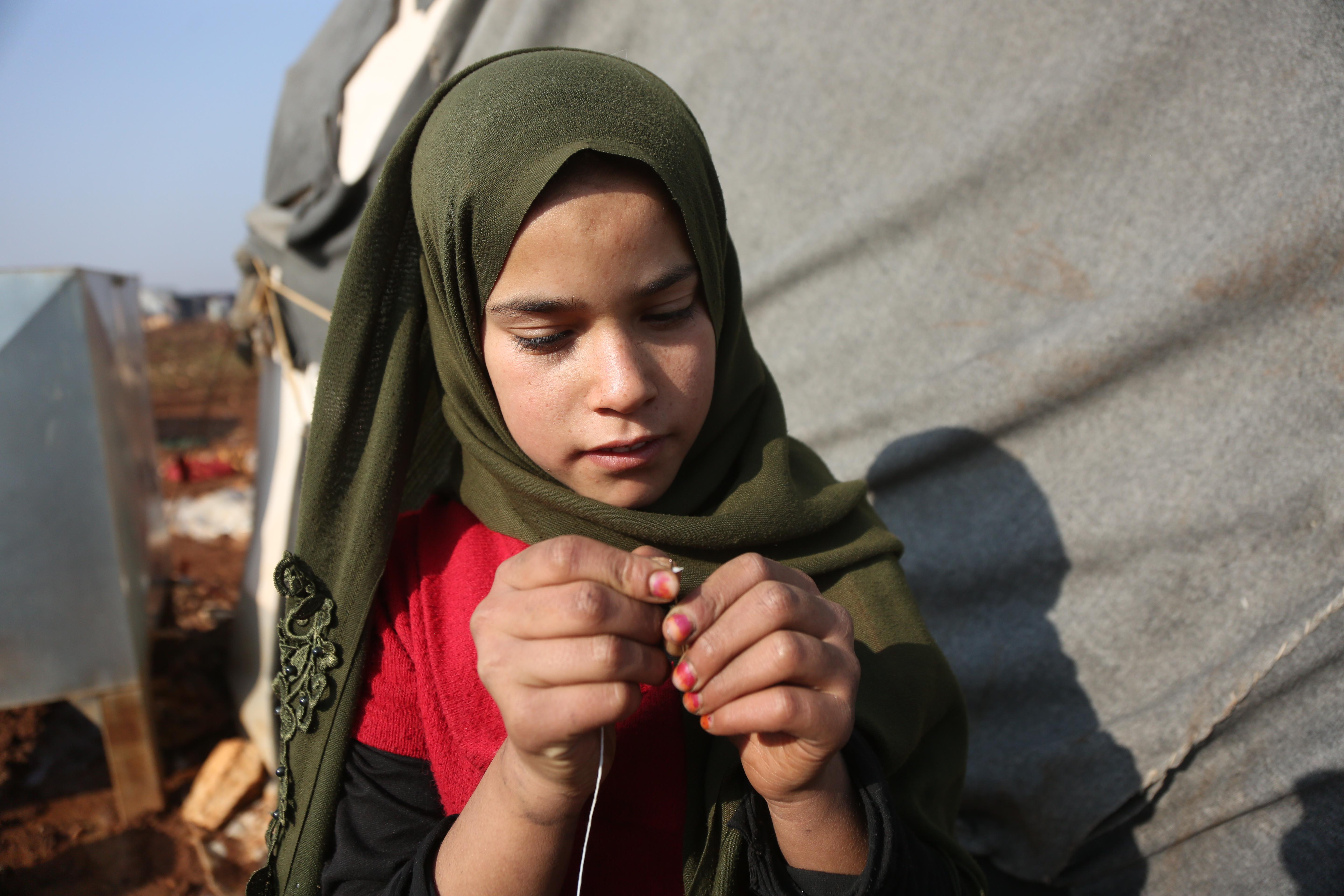 CH1641848_Hiba,_12,_works_on_sewing_tents_in_the_camp_where_she_lives