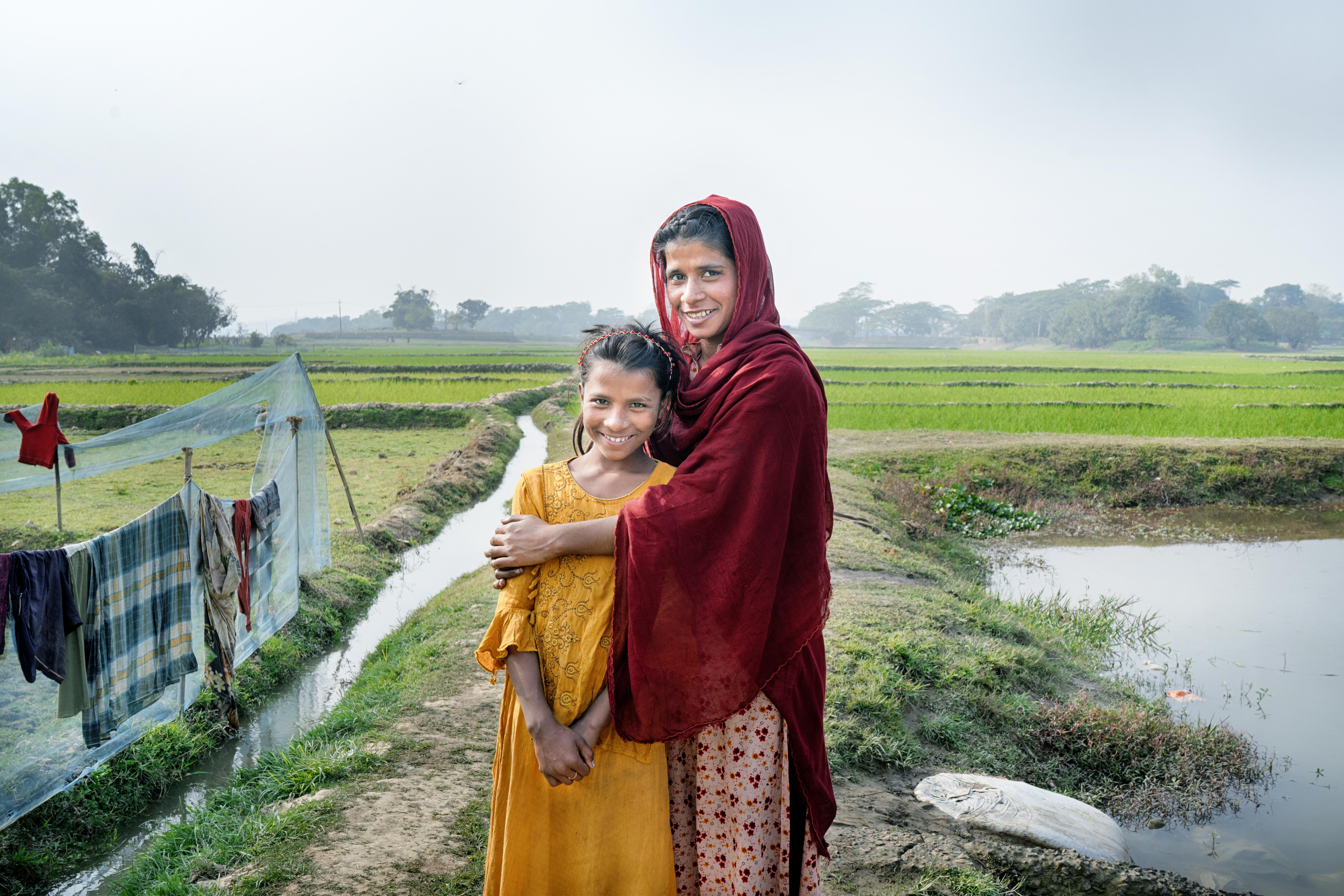 CH1785574_Portrait of Munni, 18, and her sister Tanni, 12, by Munni's fish pond at their home in Syl