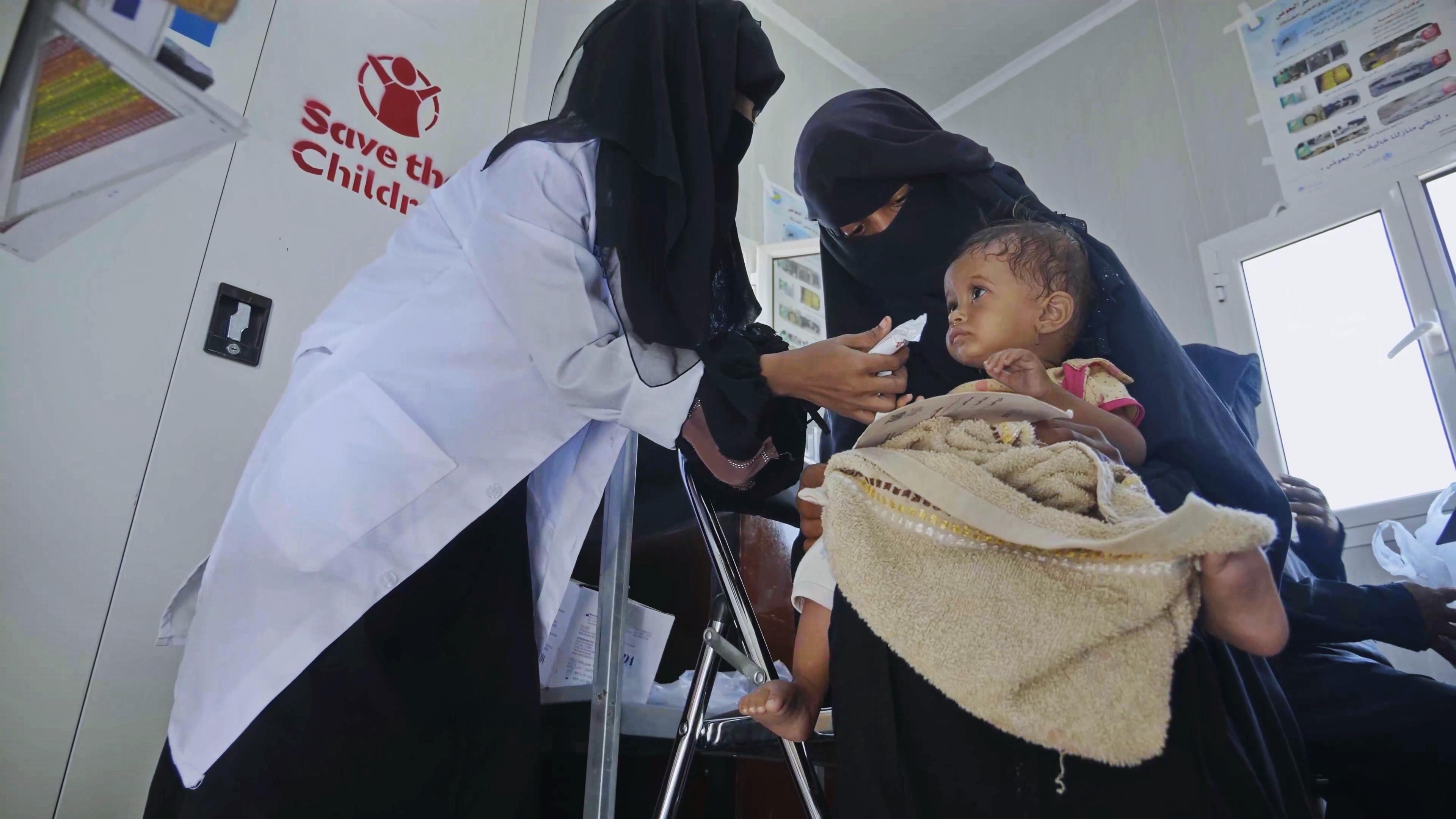 CH1795861_Dr. Khairya, 34, feeds Monira, 2, a peanut-based paste called Plumpy Nut that's used for t