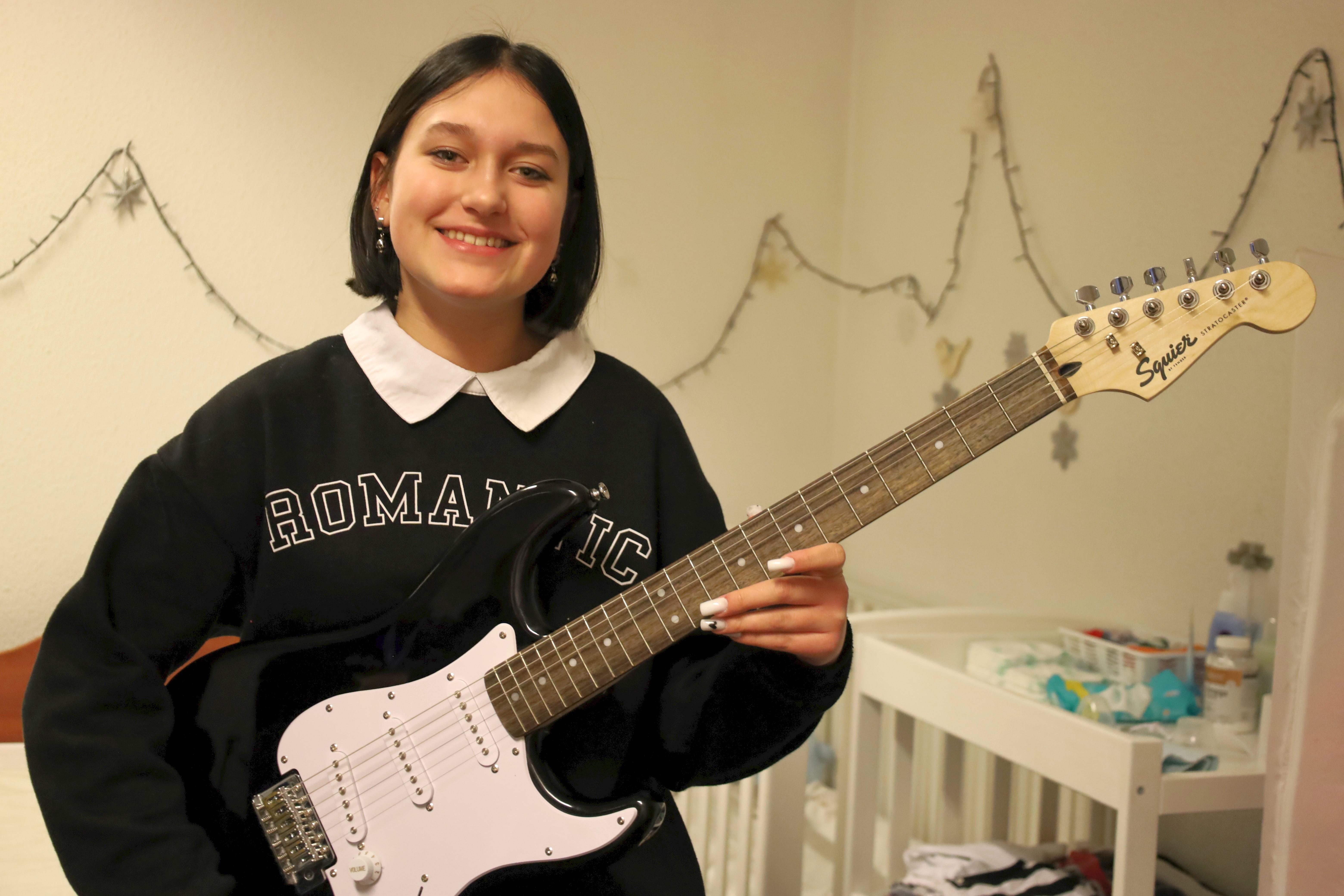CH1827514_Sofiia,_14,_holding_her_guitar_in_the_family's_home_in_Wroclaw,_Poland