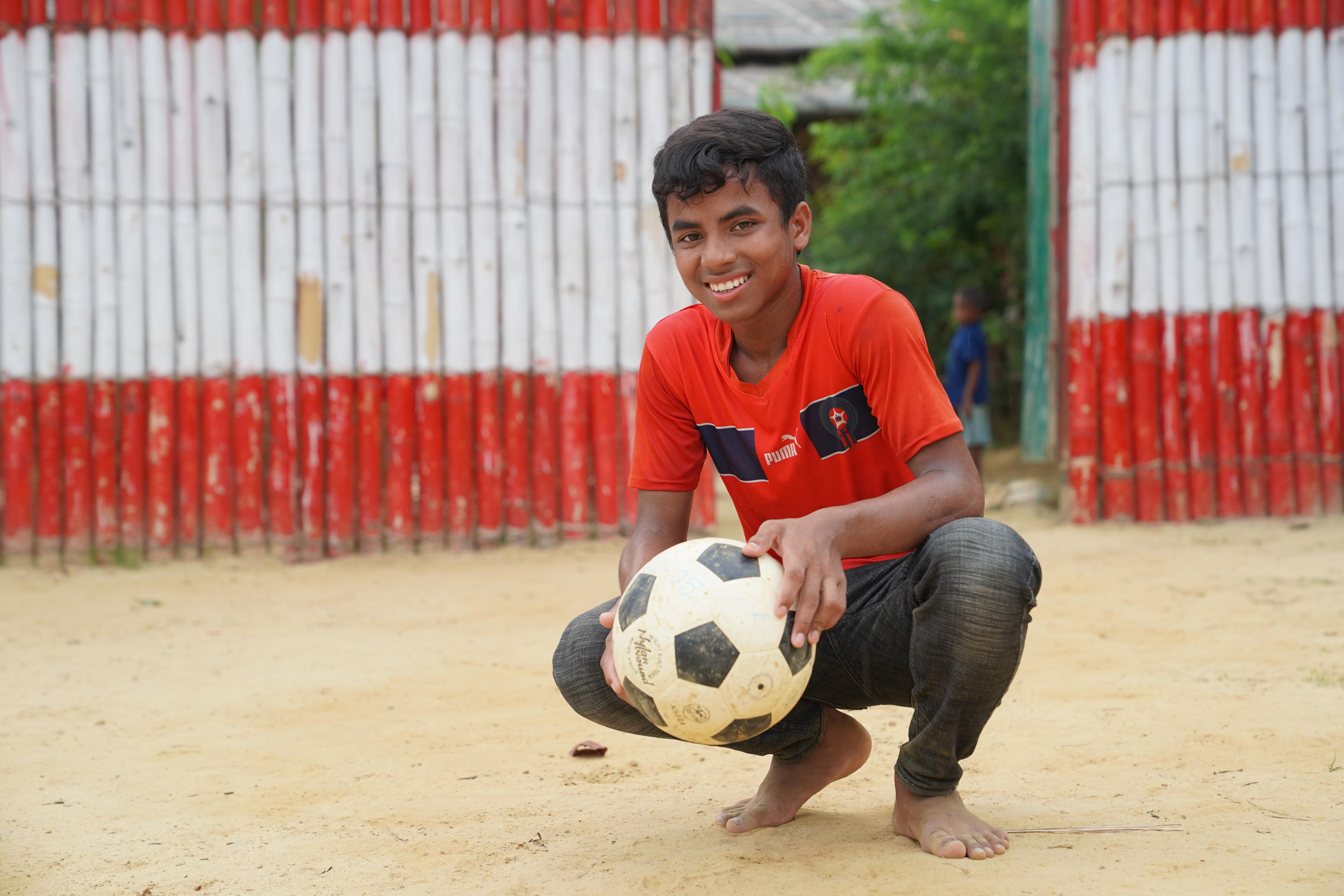 CH1830794_Tariqul_Islam,_13,_holding_his_football_in_the_field_where_he_plays_football_with_his_frie