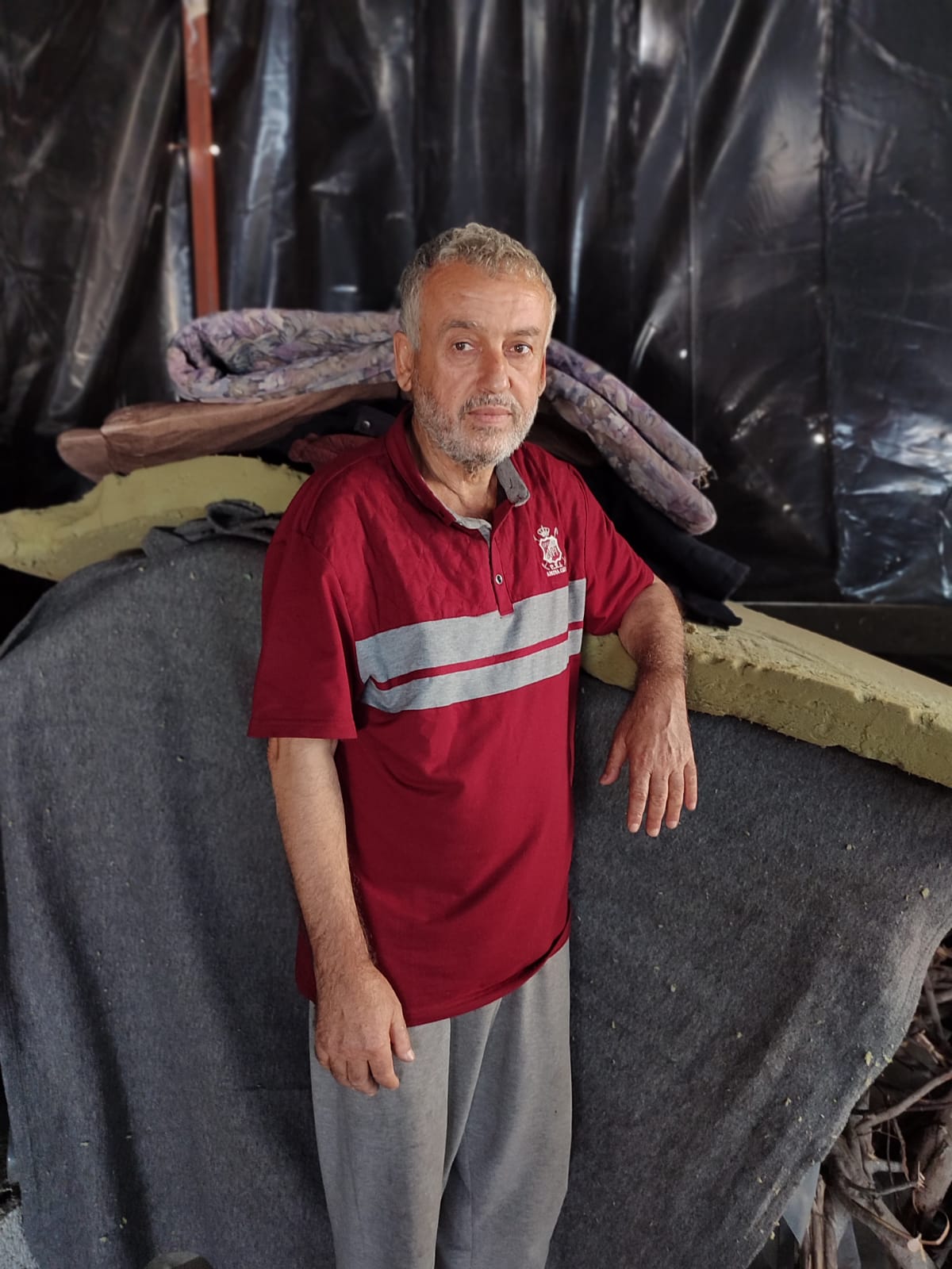 CH1929619_Fadl, 62, standing in the shelter where the family lives