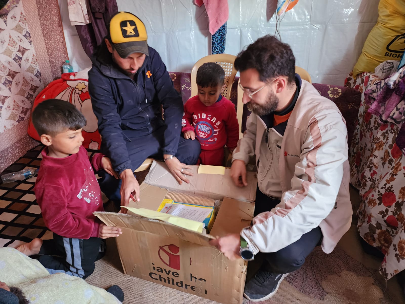 CH1965987_Omar and sons Ali and Ahmed inspecting the food parcel