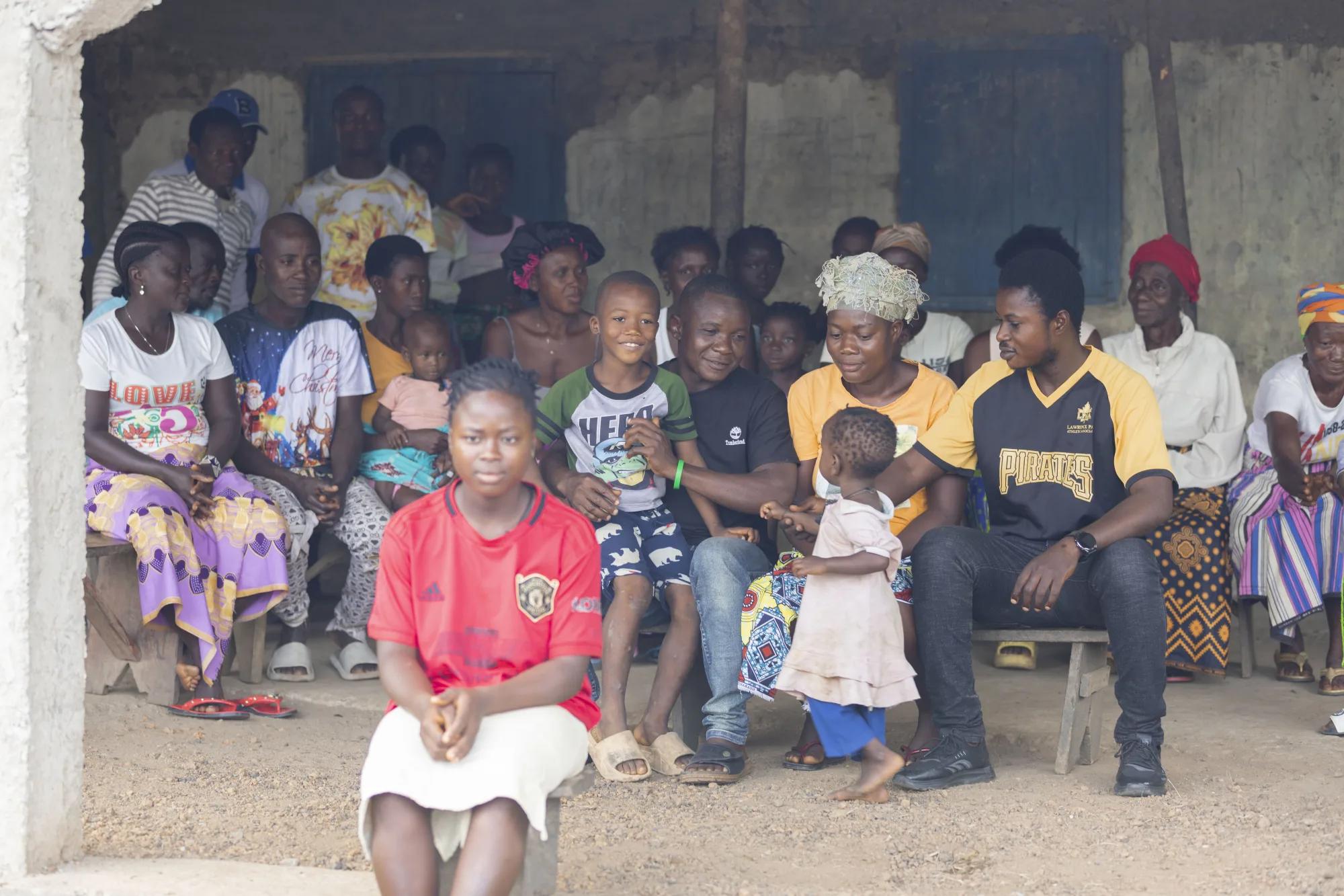 Messie with her extended family outside of their home.