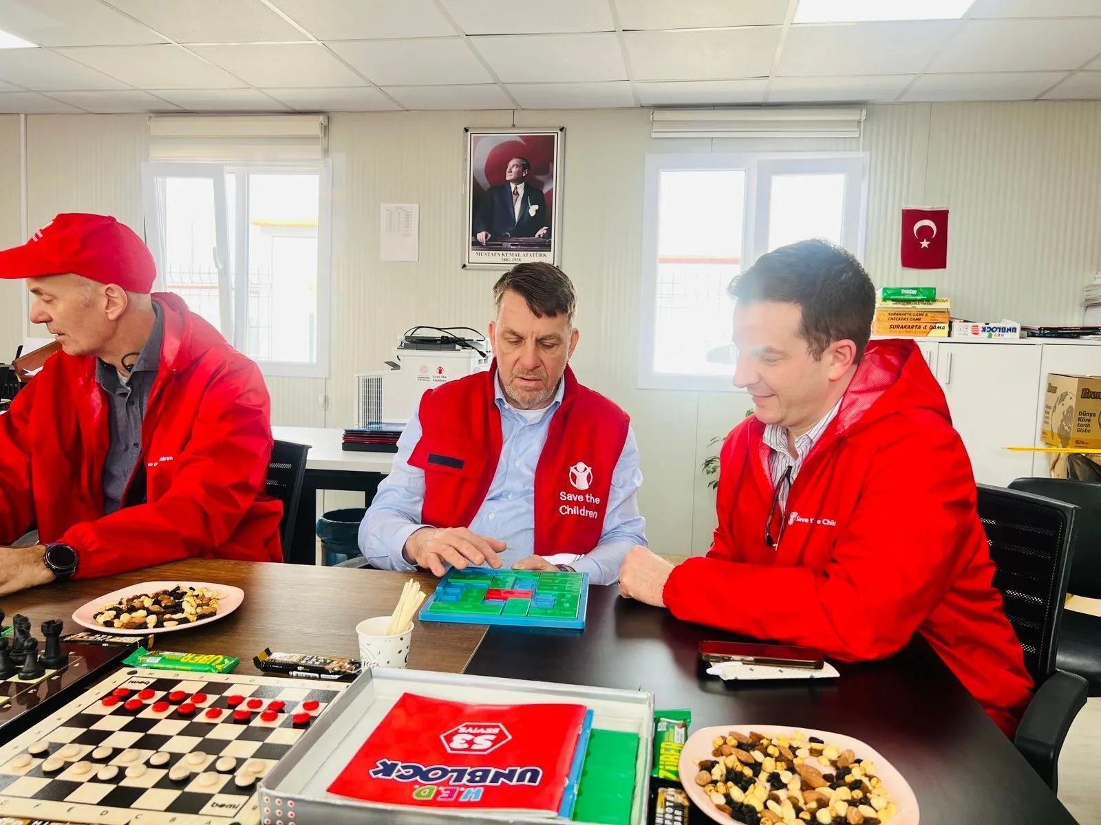 Danny (right) is shown games used by children at one of the Save the Children classrooms.