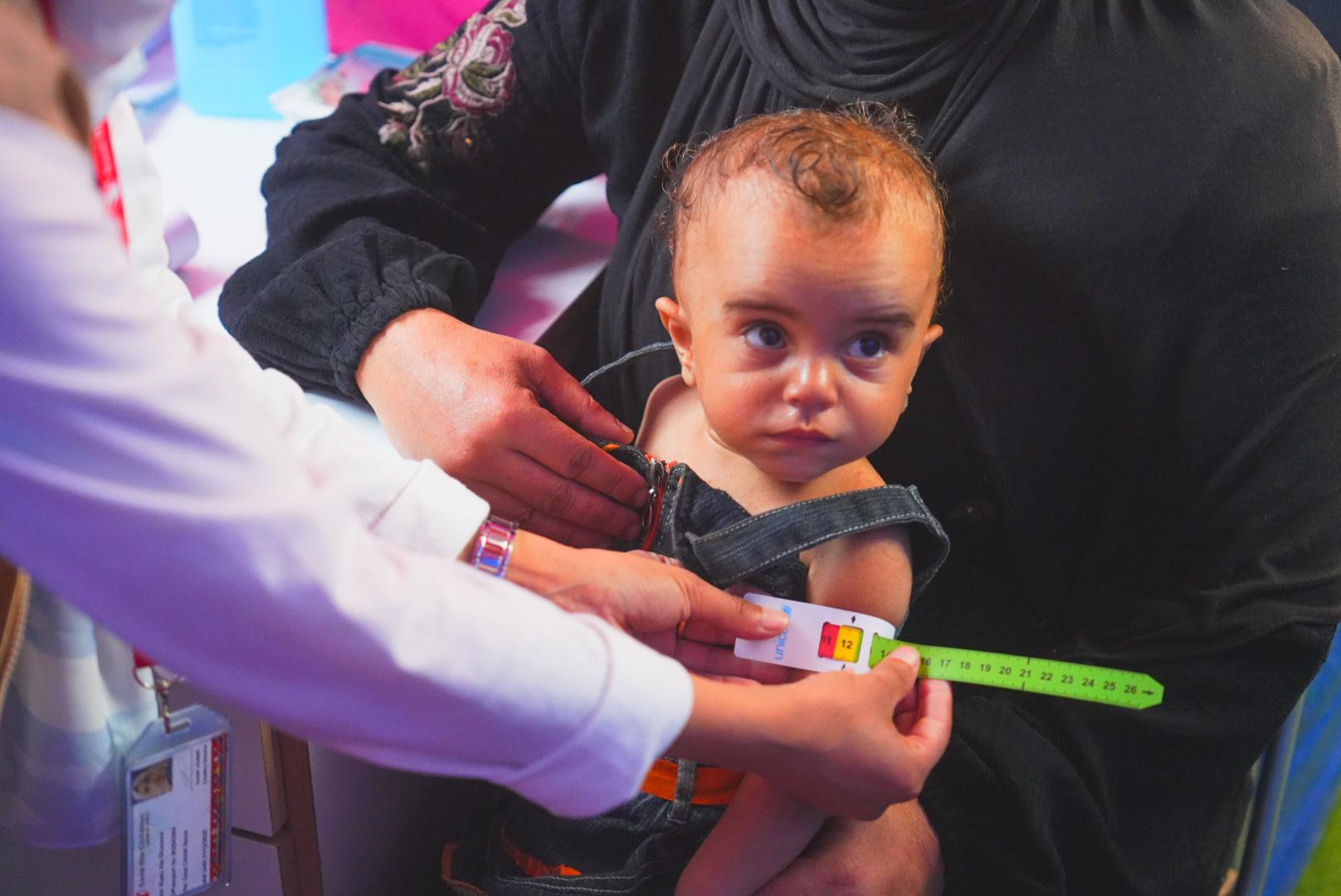 Alma*, 18 months, getting checked for malnutrition at Save the Children clinic