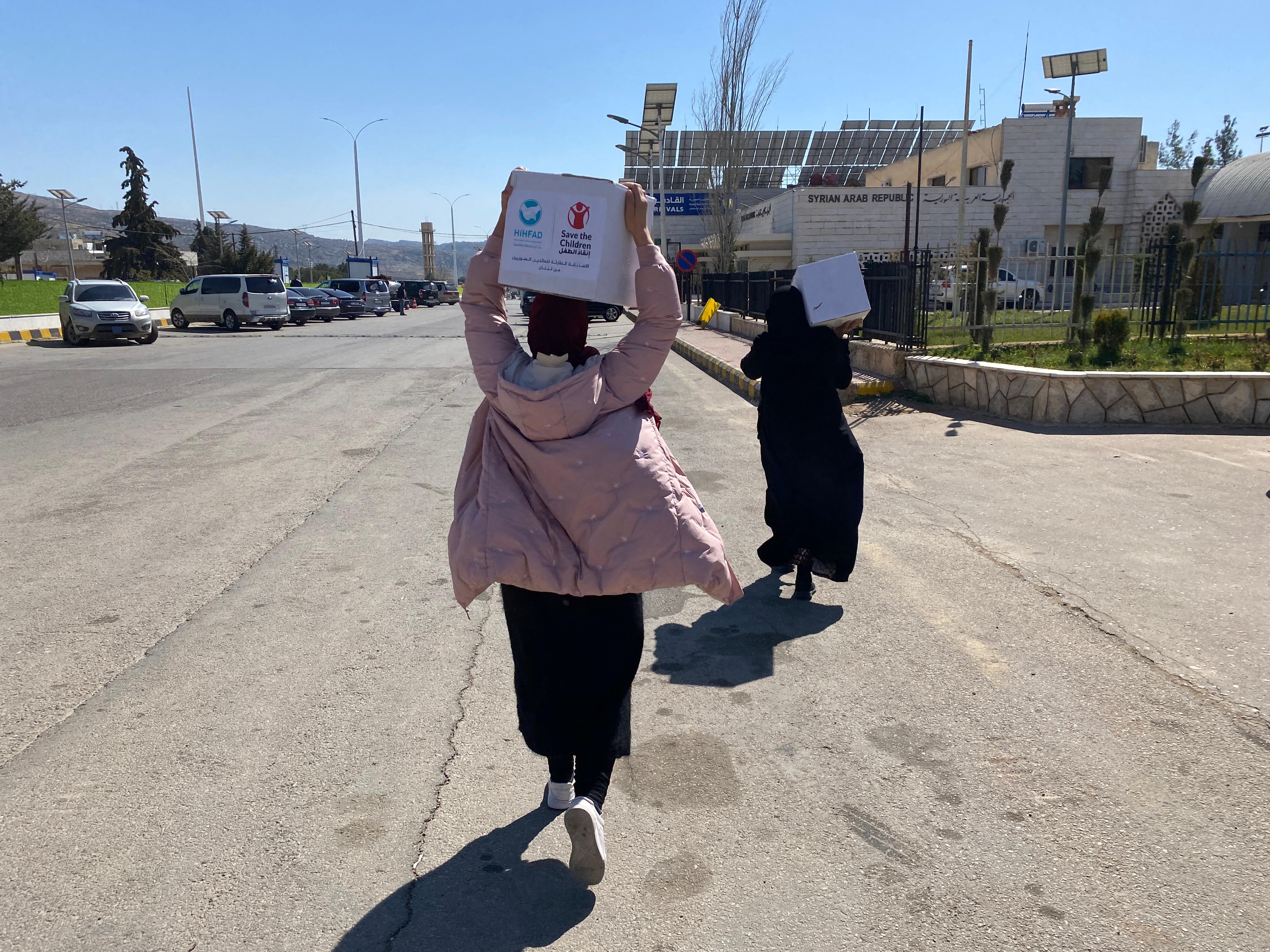 Amina* carries aid after returning from Lebanon at Jdeidet Yabous (Masnaa) crossing