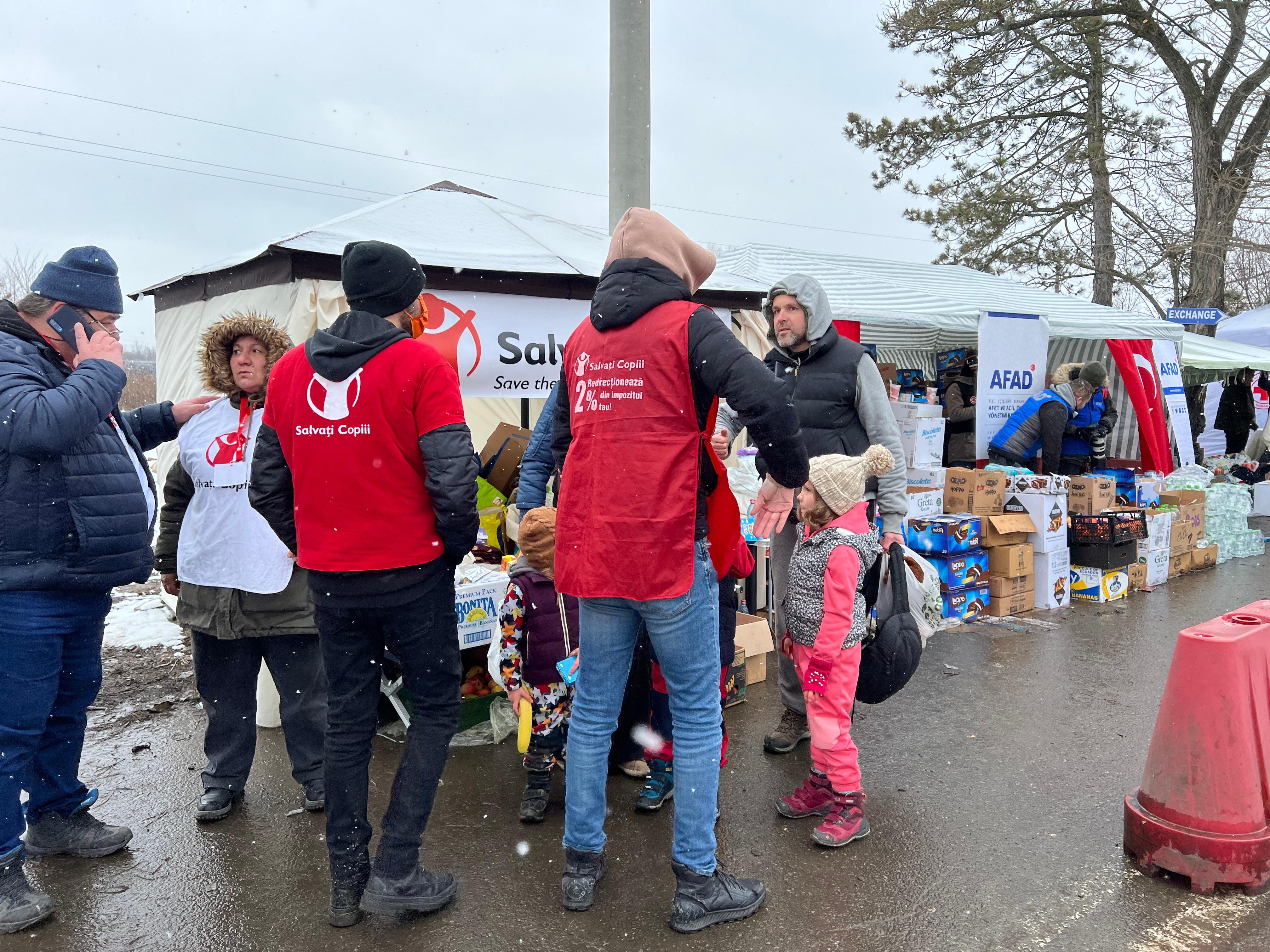 Artem*, Nadia* and their three children speak with volunteers at the border