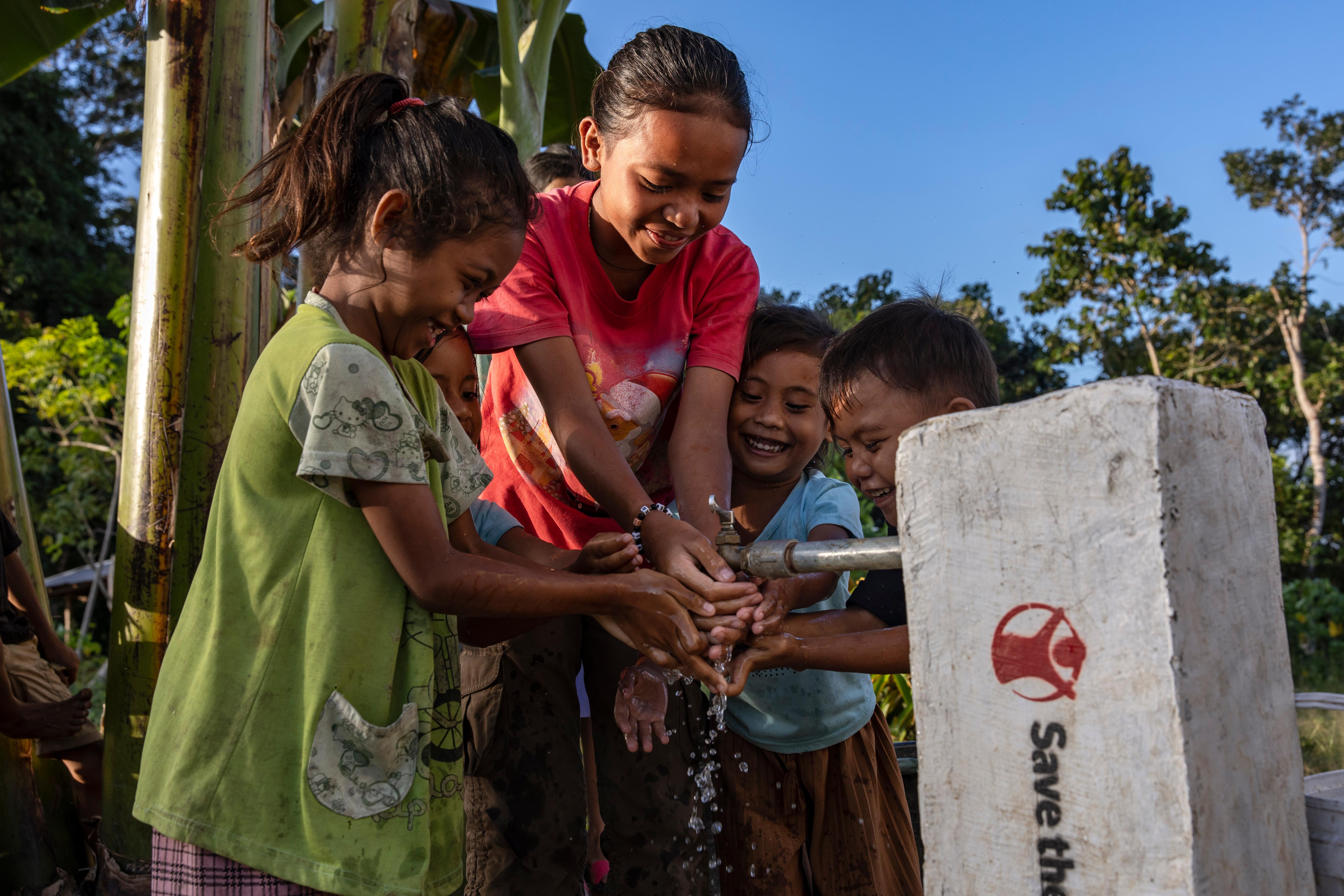 Children fetch water from one of nine taps supplying clean drinking water from a facility designed by Sandi, Soleman, and Anjar in West Sumba, Indonesia.