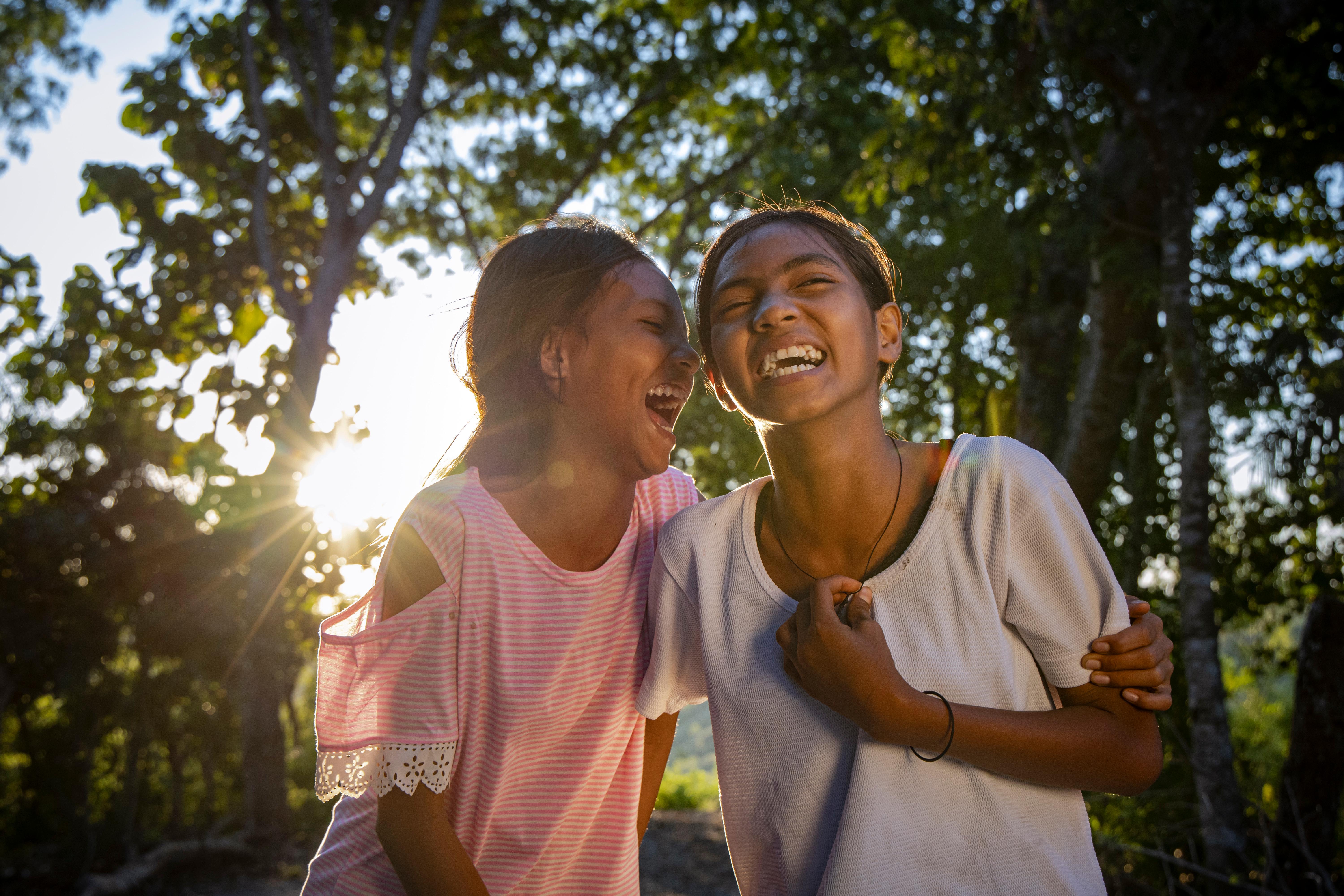 Cousins Atika and Dwi, both 12, laughing in their village in drought-affected East Sumba, Indonesia.