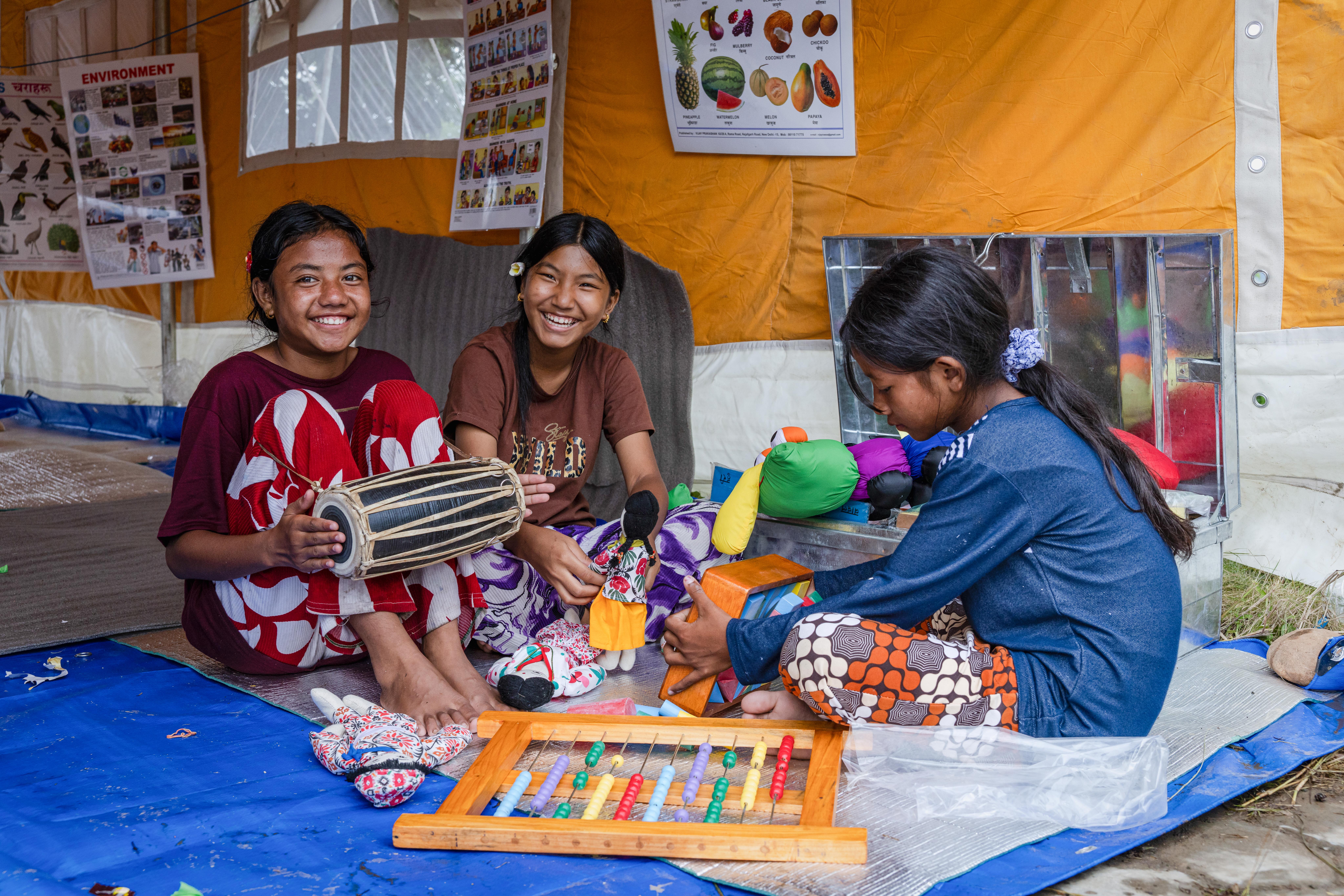 Friends Sapana* and Kala*, both 13, and Prativa*, 15, play at a Save the Children temporary learning space in Nuwakot, Nepal.