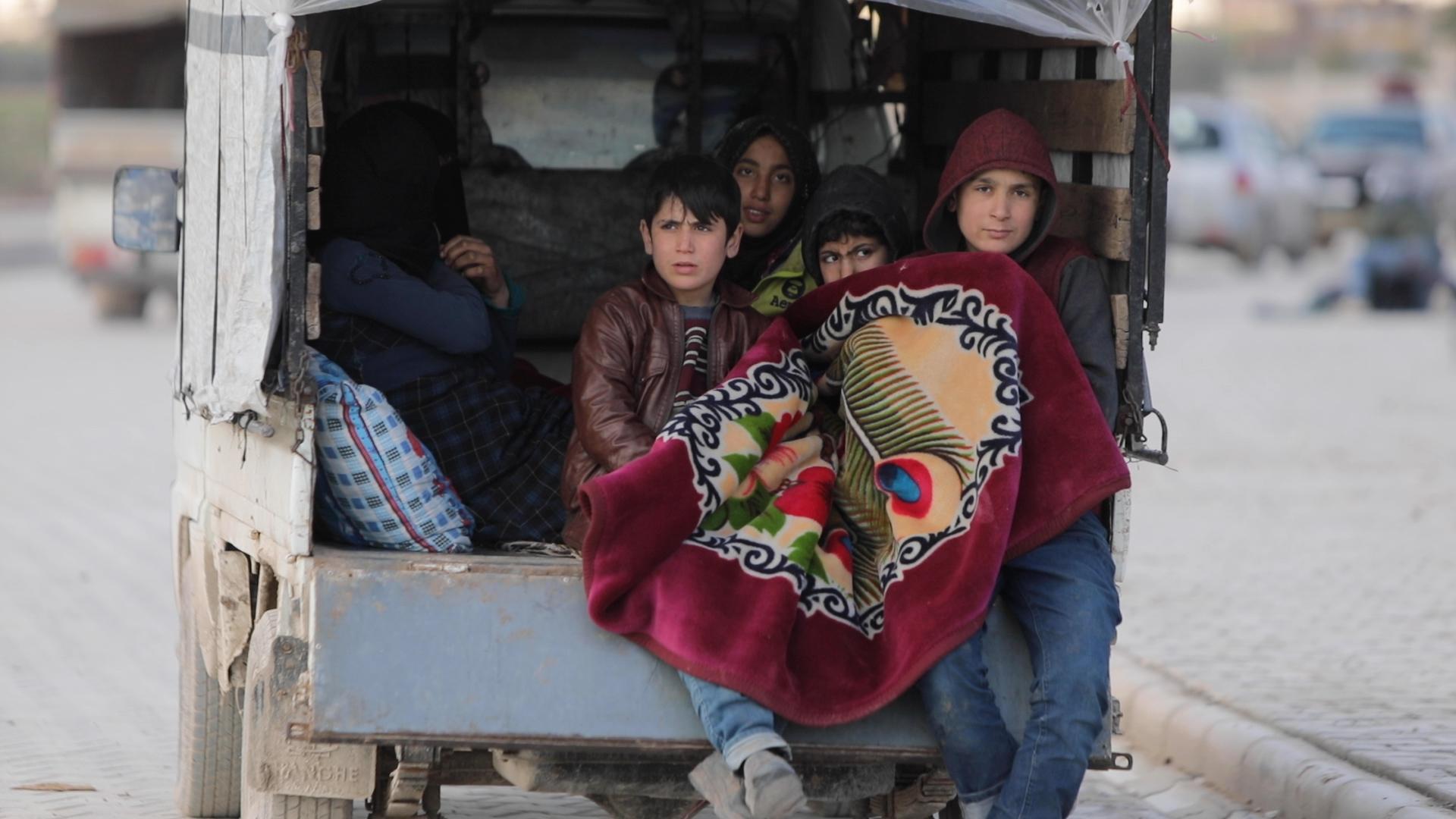 Iyad*, 15 (right) with his family in the car where they are now living