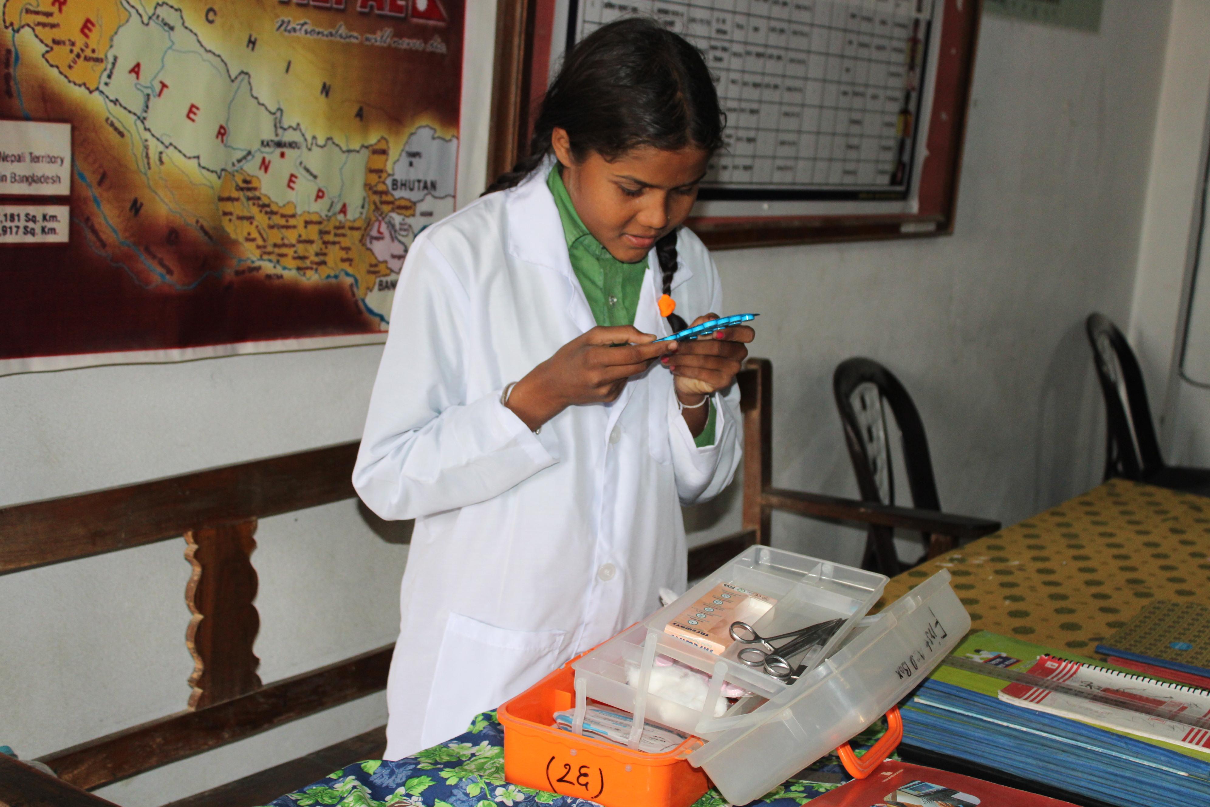 Pushpa checks the expiry dates of her school's first-aid kit, ensuring supplies are safe and ready to use