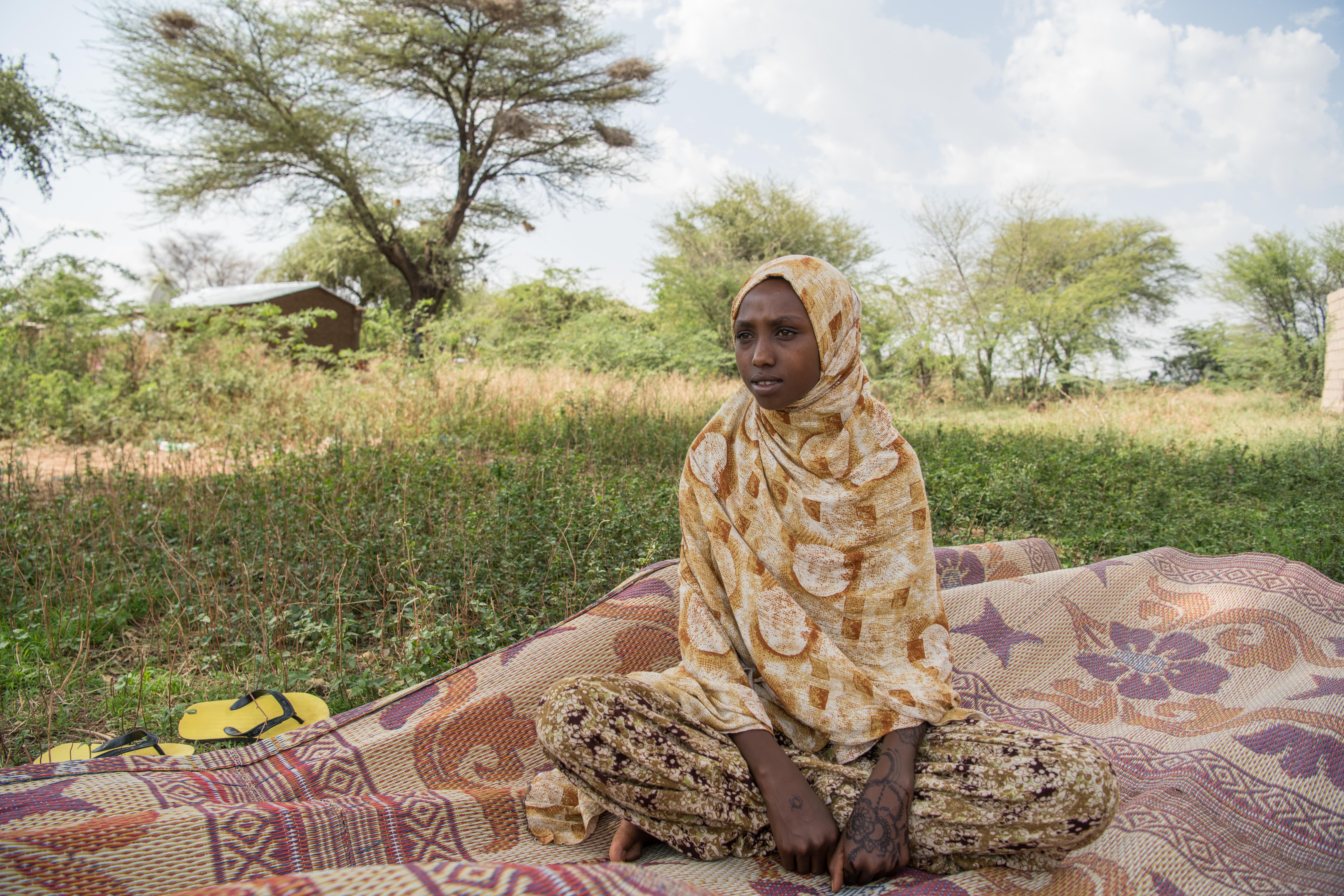 Salma*, 13, sits near her family's home in a displacement camp in the Somali region, Ethiopia.