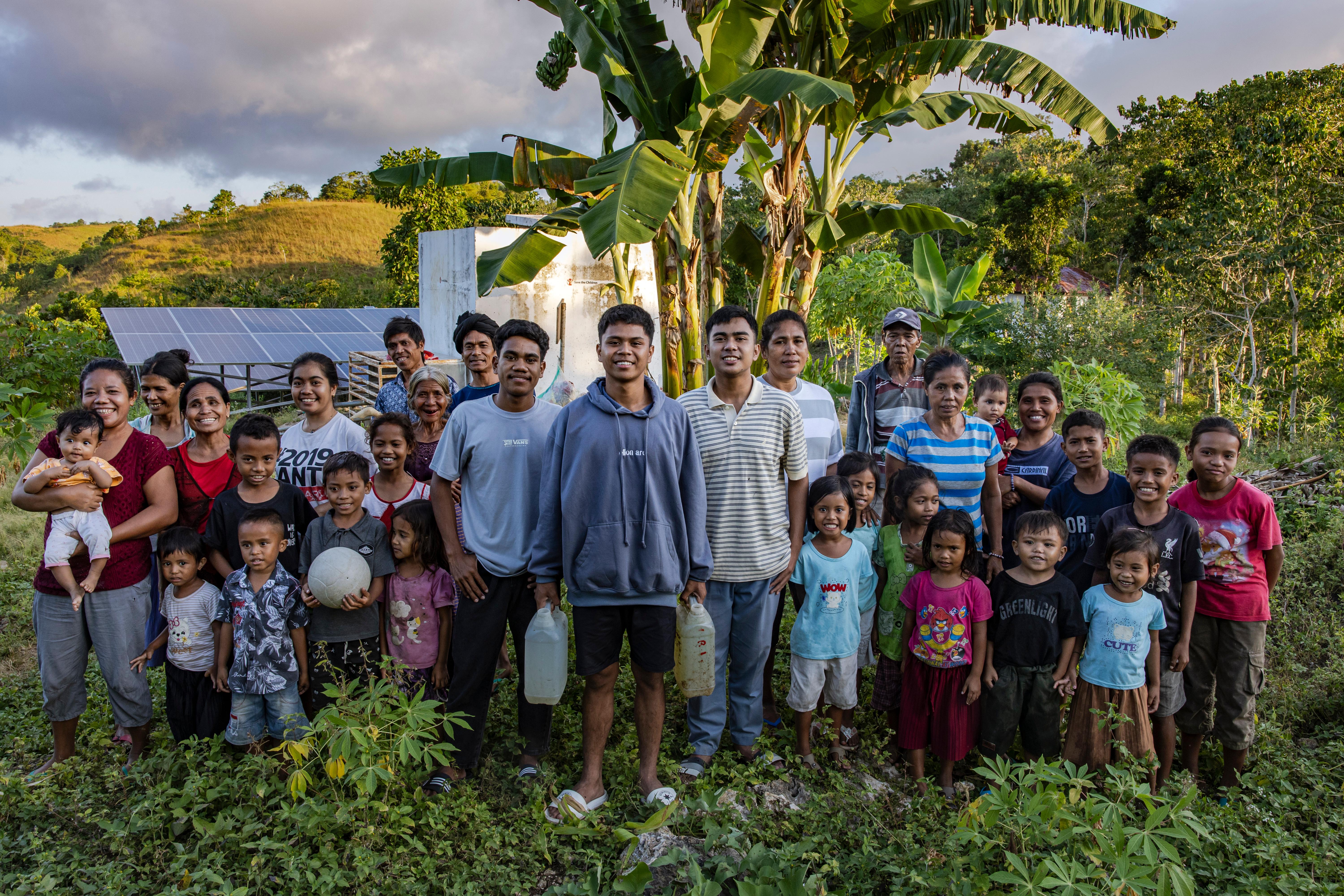 Sandi, Soleman, and Anjar, and families from Sandi’s village, in front of the water system they’ve designed in West Sumba, Indonesia.