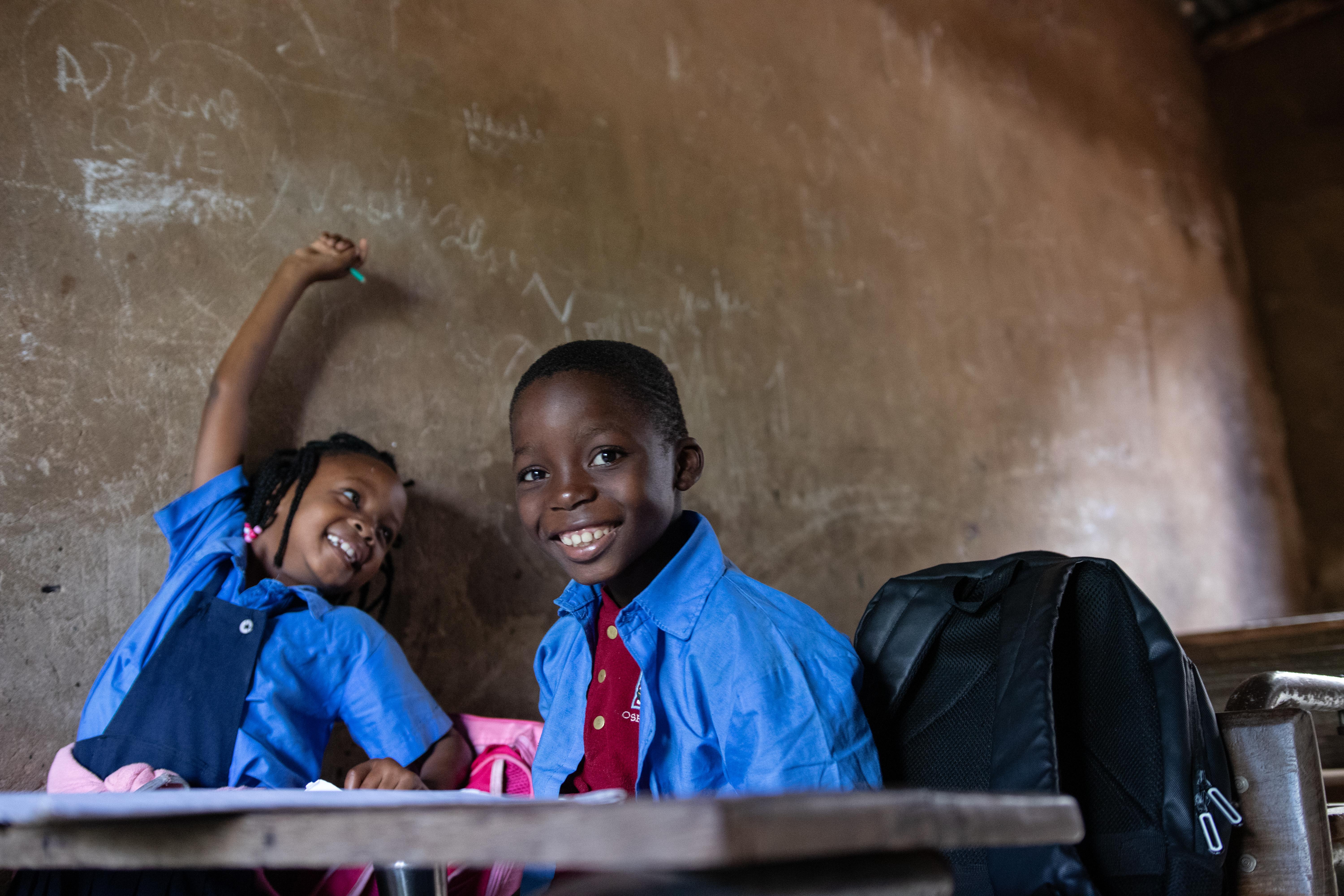 Students Alina (8) and Winderson (7) sit together during a lesson