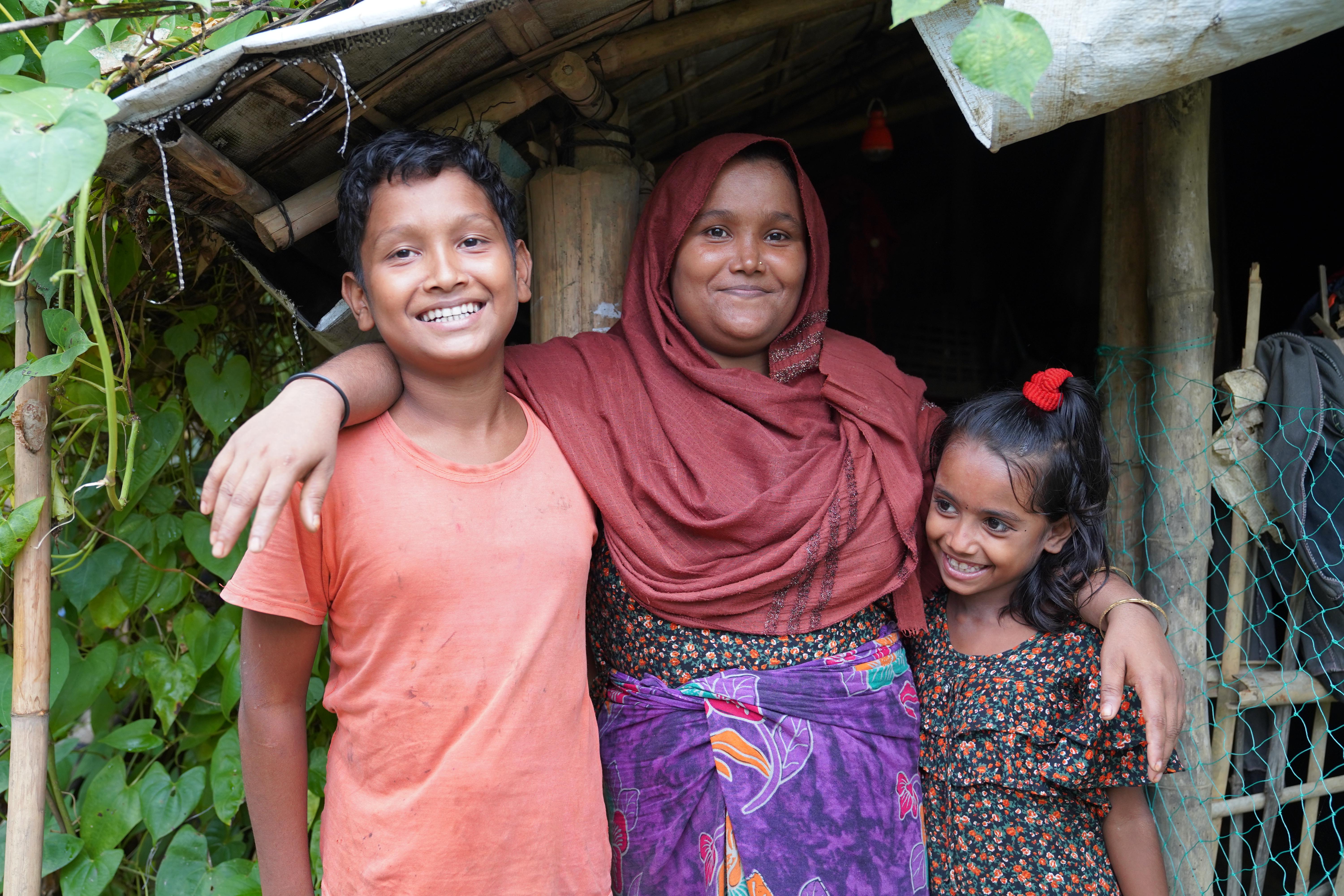 Sultana*, 7, Rakib*, 12, & Mahbuba*, 31, standing in front of their house in Cox's Bazar, Bangladesh