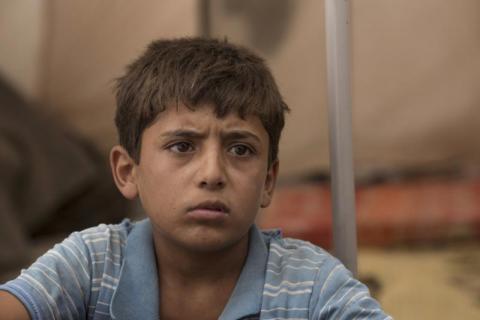 Yacoub*, 12, from Raqqa, Syria, sits inside the tent in which he and his family now live, in a camp for people displaced by the war against ISIS in Syria.