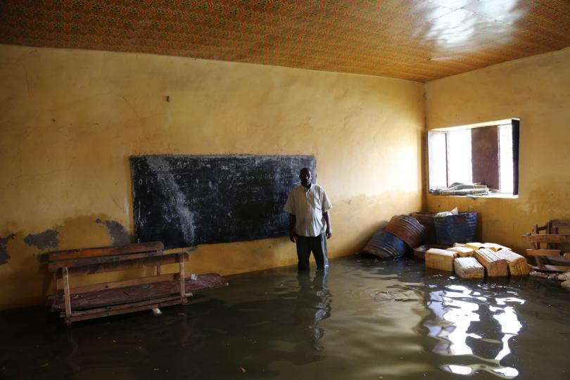 Abdi stands in the flooded classroom at the school where he teaches in Somalia 