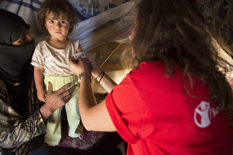 A girl is checked for malnutrition