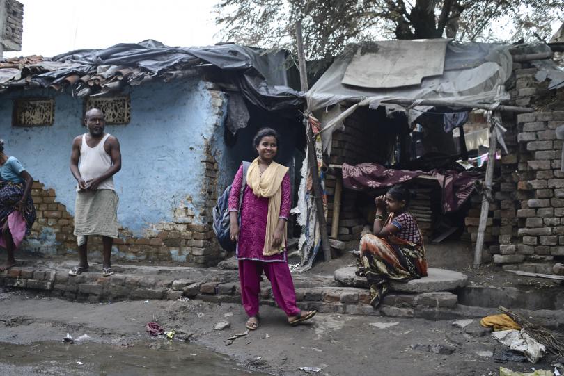 Munni stands outside the entrance to her house