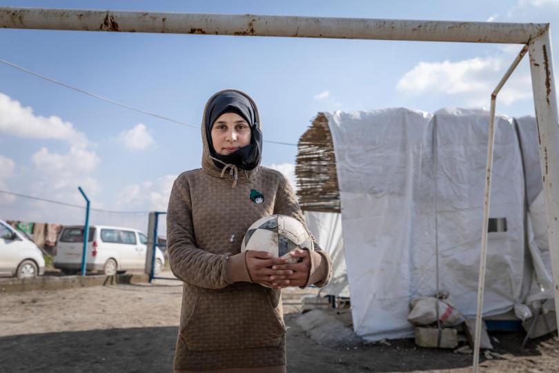 Sara*, 14, holds a football at Save the Children’s Child Friendly Space, Syria.