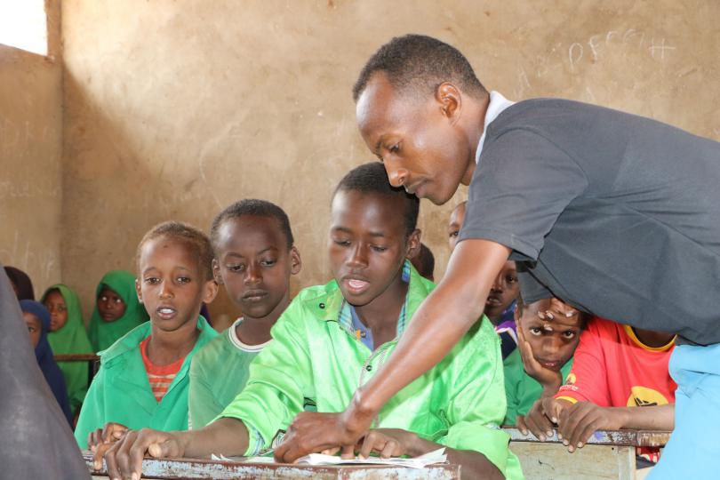 Teacher Mohammed helps children during science class in Somalia (before COVID-19)