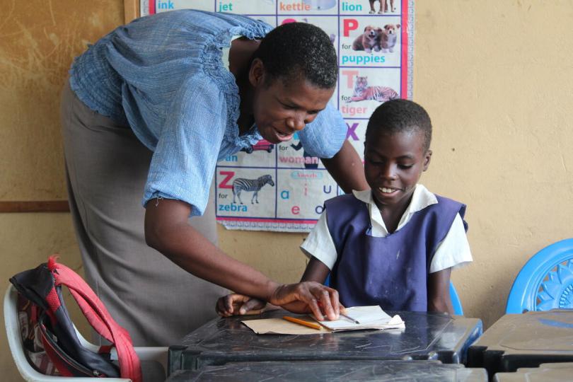 Kabukabu, 9, with her teacher at her local primary school, Zambia