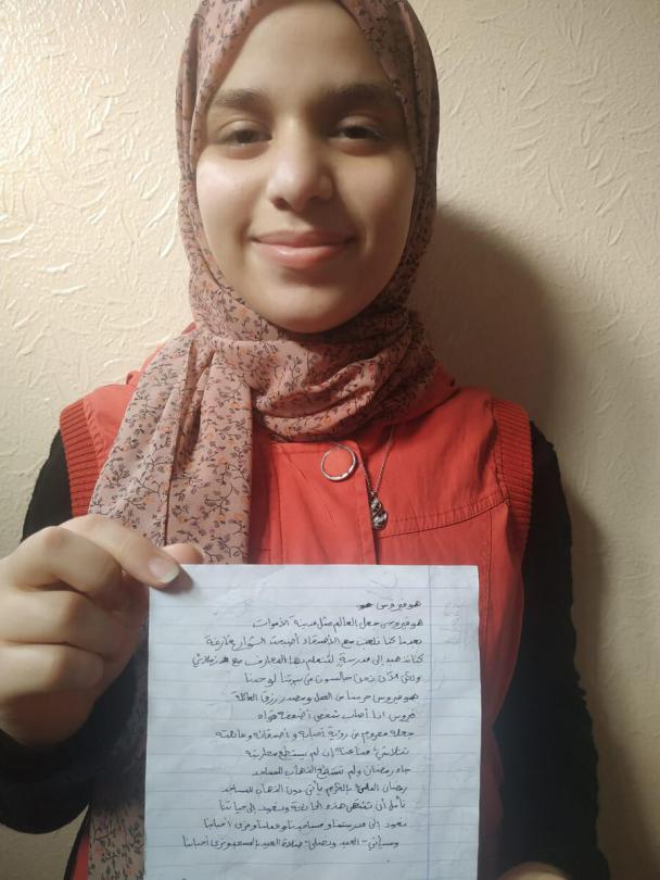 Mariam* holds her poem about coronavirus, Gaza