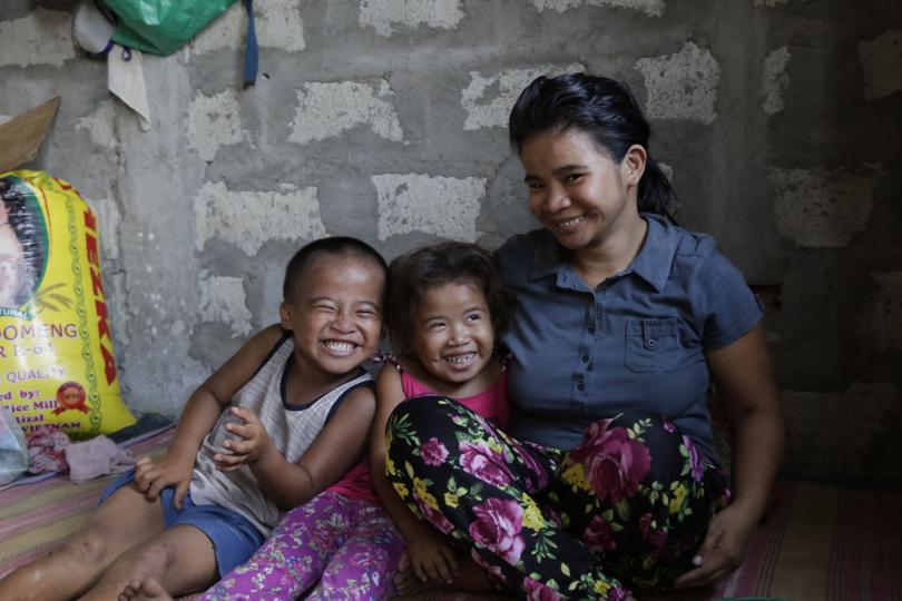 Merlina*, 26, with Timothy*, 6, and Feliza*, 5, giggling together at home, Philippines