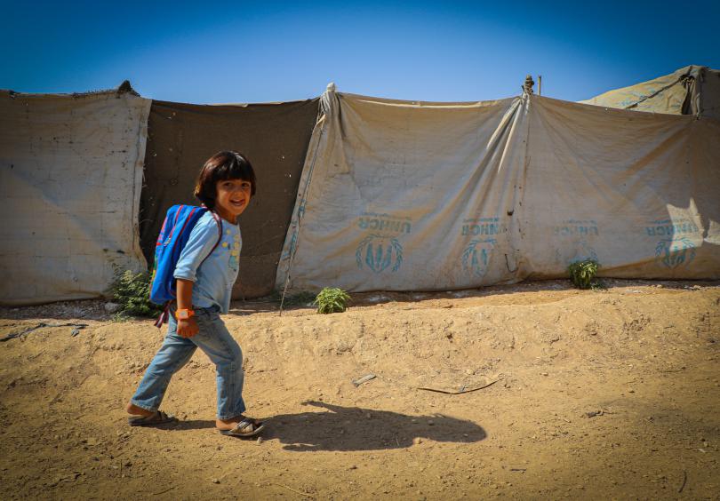 A child walks to school with a smile on her face