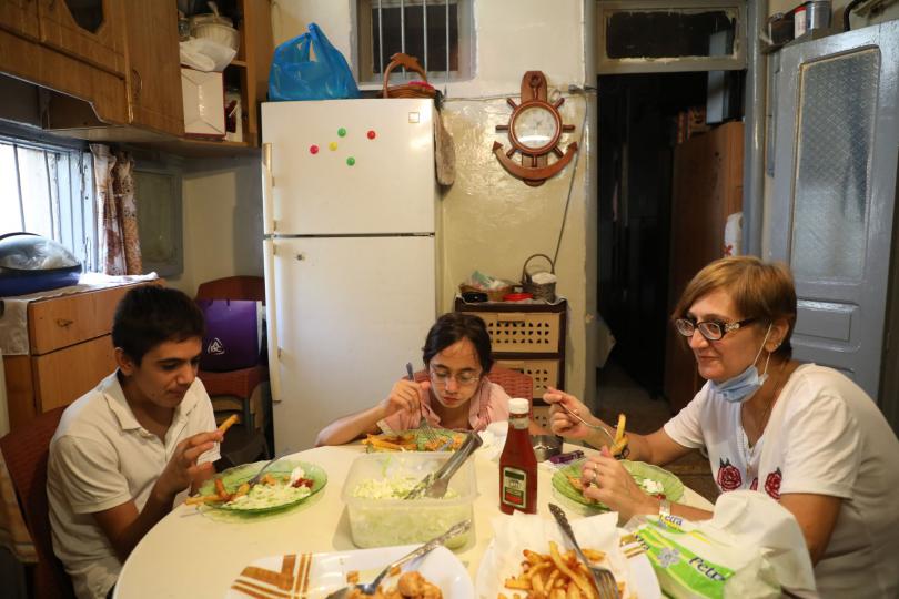 Mum Marie-Helene, Jad*, 14, and Lama*, 11, sit down to a dinner of Taouk chicken, French fries and salad