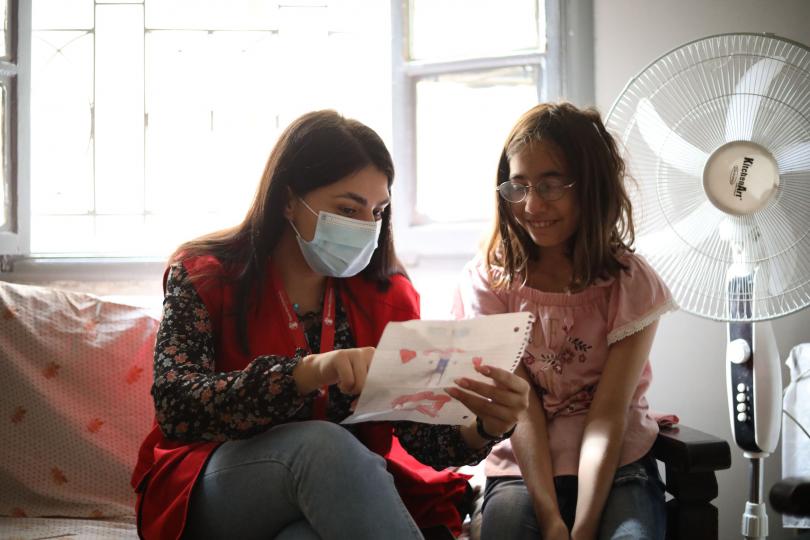 Case worker Hanaa discusses a drawing with Lama*, 11, Beirut, Lebanon