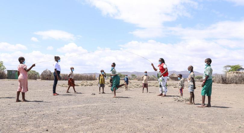 Save the Children staff playing with children in the community