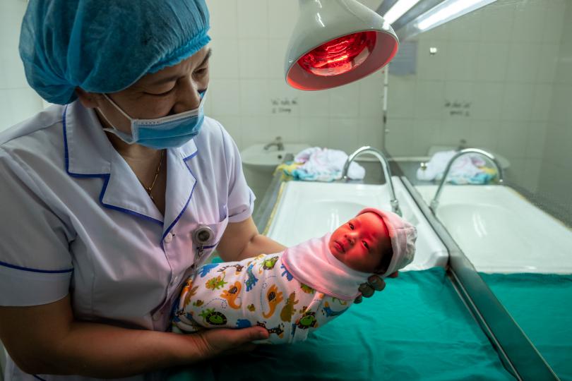 One-week-old Bao Chau is bathed by a midwife at Nghia Lo General Hospital, Vietnam