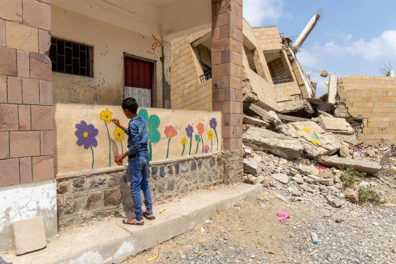 Children in Yemen paint a flower mural on the walls of a destroyed school as part of the Flowers for Children campaign