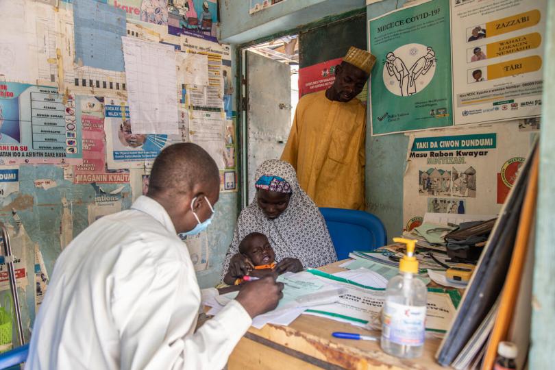 Healthworker Yau, 41, examines nine-month-old Bashir at a village health post in Jigawa State, Nigeria.