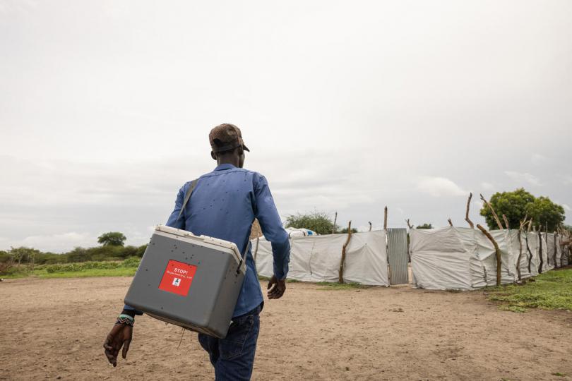 Community health worker Kim carriess a cold box storing vaccines to a remote community in Akobo West, South Sudan.