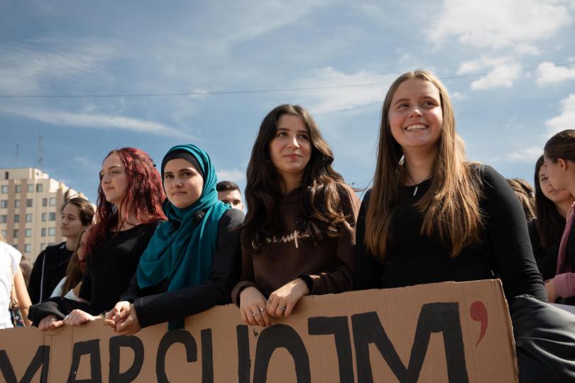 Festina, 16, Sara, 15, More, 14, and Rona, 14, pictured holding a sign at a climate march in Prishtina, Kosovo