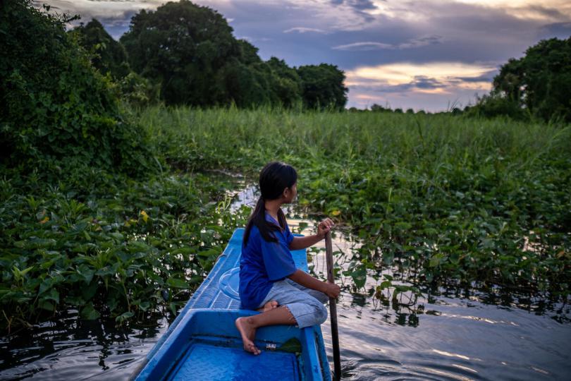 Sreyvatey, 14, looking for plants near her home on Tonle Sap Lake, Cambodia