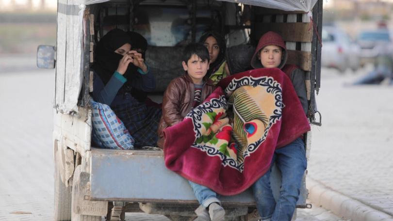 Iyad*, 15 (right) with his family in the car where they are now living