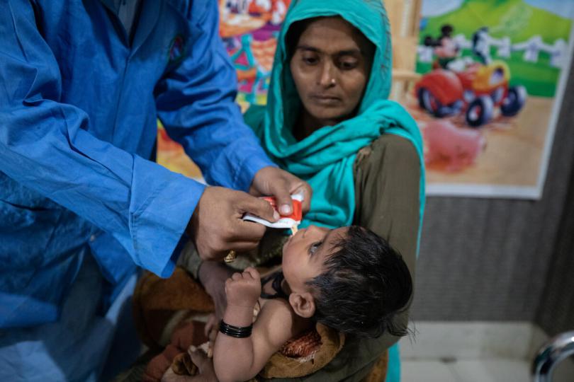 Waheed, nutrition assistant, feeds RUTF to Jaiyana*, 10-months.