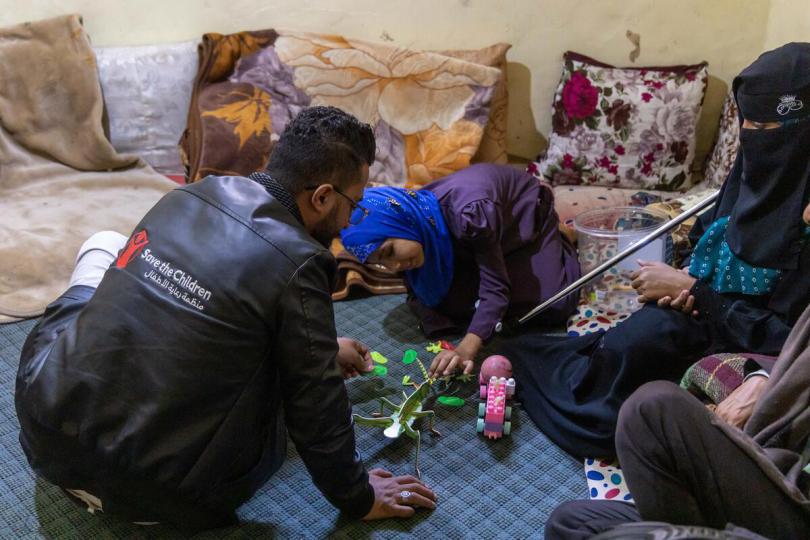 10-year-old Maha* & 16-year-old Maya* play with Jihad, a Save the Children psychosocial support volunteer who survived a landmine.