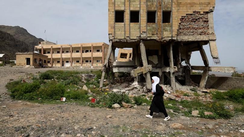Lina, 12, walks around the grounds of her semi-destroyed school that's contaminated with landmines in Taiz, Yemen
