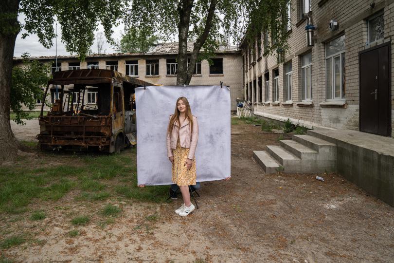 Kateryna*, 16, poses for a portrait at her damaged school outside of Kyiv (Oleksandr Khomenko/Save the Children)