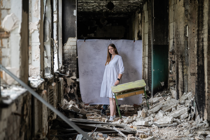Olena*, 17, poses for a portrait at her damaged school outside of Kyiv (Oleksandr Khomenko/Save the Children)  