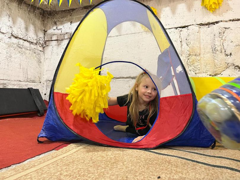 Olena*(4) plays in the sports area in the bomb shelter of her kindergarten