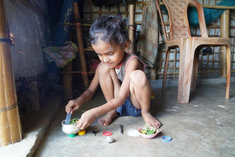 Antora, 5, helps her mother prepare a meal with their food rations in Cox's Bazar, Bangladesh