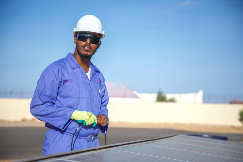 Mohamed, 24, working on a solar panel