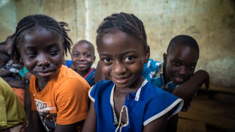 A girl smiles in her classroom in Sierra Leone